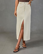 Cream corduroy high-waist midi skirt with front slit, styled with brown bodysuit and black flip-flops