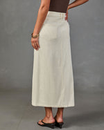 Cream corduroy midi skirt back view with patch pocket, worn with brown bodysuit and black heeled sandals