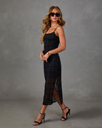 Black plaid sheer midi slip dress with side slit, styled with black strappy heels, gold cuff and sunglasses