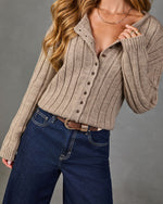 Woman wearing taupe ribbed knit button-down cardigan sweater with dark wide-leg jeans and brown leather belt