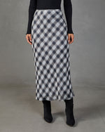 Navy plaid bias-cut satin midi skirt styled with black ribbed turtleneck and knee-high boots