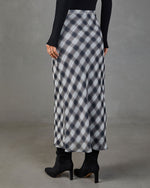 Women's bias-cut plaid midi skirt in navy and white with black ribbed top and black suede heeled boots