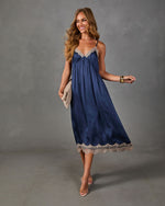 Navy satin midi slip dress with beige lace trim, styled with a woven clutch, gold bangle and clear strappy heels