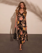 Black floral maxi slip dress with lace neckline, pink and gold flowers, worn with black sandals and woven tote bag