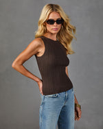 Woman wearing brown ribbed knit sleeveless tank top with light blue jeans, gold bangles, and tortoise sunglasses