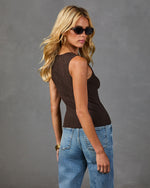 Woman wearing dark brown ribbed knit tank top and light wash jeans, styled with tortoise sunglasses and gold hoop earrings
