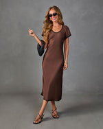 Brown satin midi dress with black trim, short sleeves, worn with strappy black heels and woven clutch bag