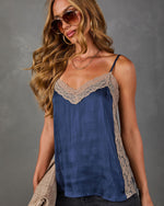 Navy satin cami top with beige lace trim, styled with aviator sunglasses, gold hoop earrings and layered necklaces