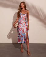 Blue and rose tropical print satin midi slip dress with cowl neck, side slit, worn with nude strappy sandals and cream clutch