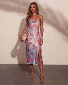 Blue and rose tropical print satin midi slip dress with cowl neck, side slit, worn with nude strappy sandals and cream clutch