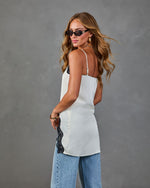White satin slip cami top with black lace trim detail, styled with wide-leg jeans and oval sunglasses, back view