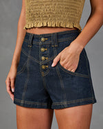 Dark wash high-waist denim shorts with gold button fly and contrast stitching, paired with khaki smocked crop top