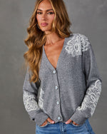 Gray V-neck cardigan with white lace appliqué on shoulder and sleeves, pearl buttons, styled with blue jeans