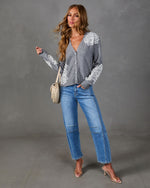 Gray button-front cardigan with white lace appliqué, styled with light-wash barrel jeans, clear heels and a cream woven bag