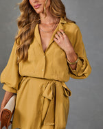 Mustard yellow button-down shirt dress with tie waist, balloon sleeves, and chest pockets on female model