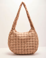 Quilted puffer hobo shoulder bag in warm beige nylon with grid pattern and single padded strap, zipper closure