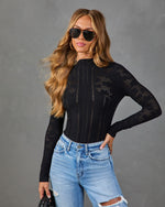 Black pointelle knit long sleeve bodysuit with mock neck, styled with light wash distressed jeans and aviator sunglasses