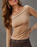 Tan velvet asymmetric off-the-shoulder long sleeve top styled with brown coated skinny jeans, gold hoop earrings and sunglasses