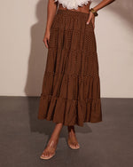 Brown polka dot tiered maxi skirt with smocked waist, styled with white ruffle crop top and nude sandals