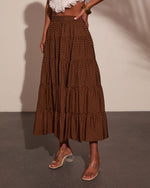 Brown polka dot tiered maxi skirt styled with white lace crop top and clear block heel sandals