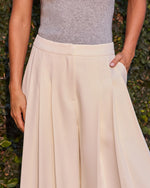 Cream pleated midi skirt with side pocket styled with grey ribbed knit top, outdoor ivy background