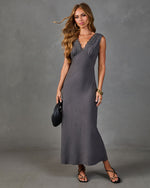 Gray lace V-neck satin maxi slip dress styled with black strappy sandals and woven clutch bag on female model